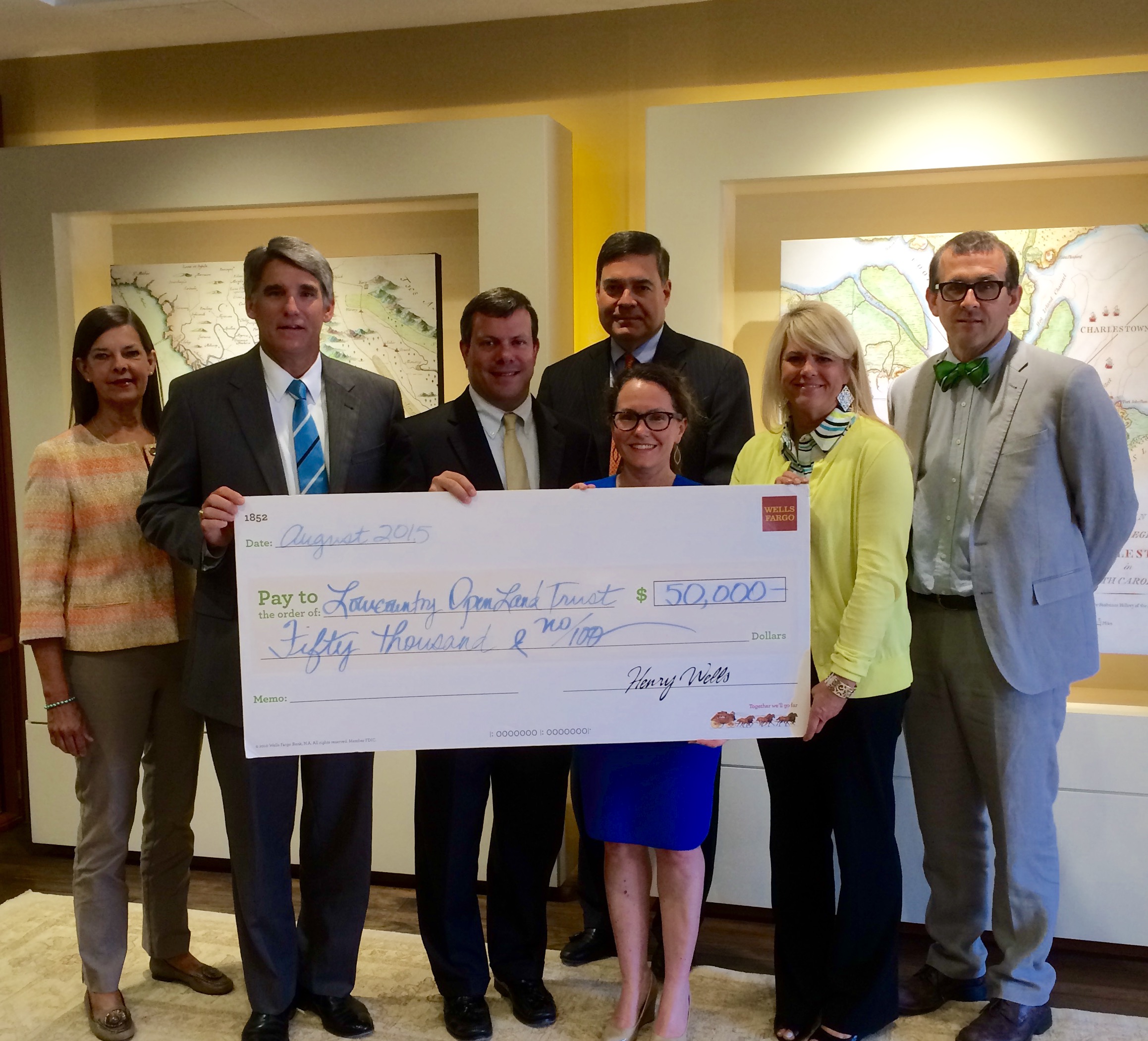 Ashley Demosthenes and Garrett Budds accept check on behalf of Land Trust